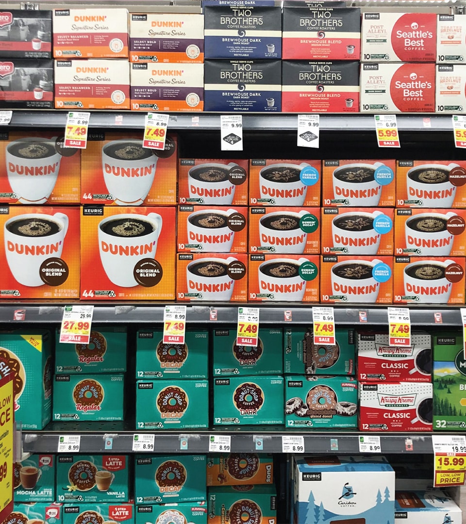 Dunkin coffee packaging design on retail shelf showing K-Cup pods and ground coffee products by Kaleidoscope