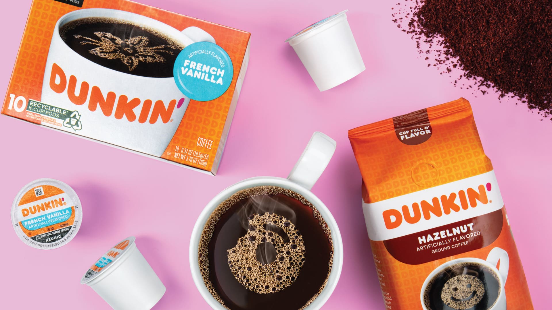 Dunkin French Vanilla K-Cup box and Hazelnut ground coffee bag packaging design flatlay with coffee mug on pink background by Kaleidoscope