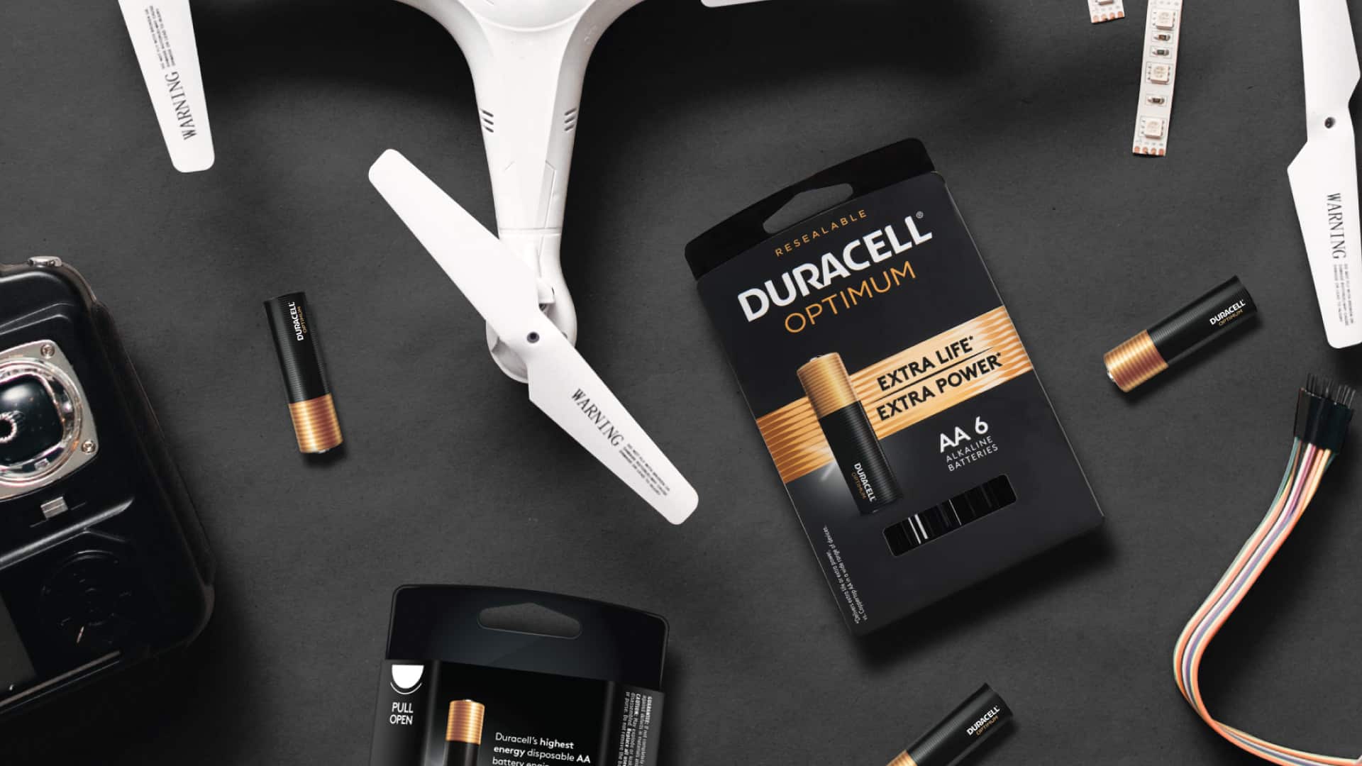 Duracell Optimum AA battery resealable packaging lifestyle flatlay with drone and electronics by Kaleidoscope